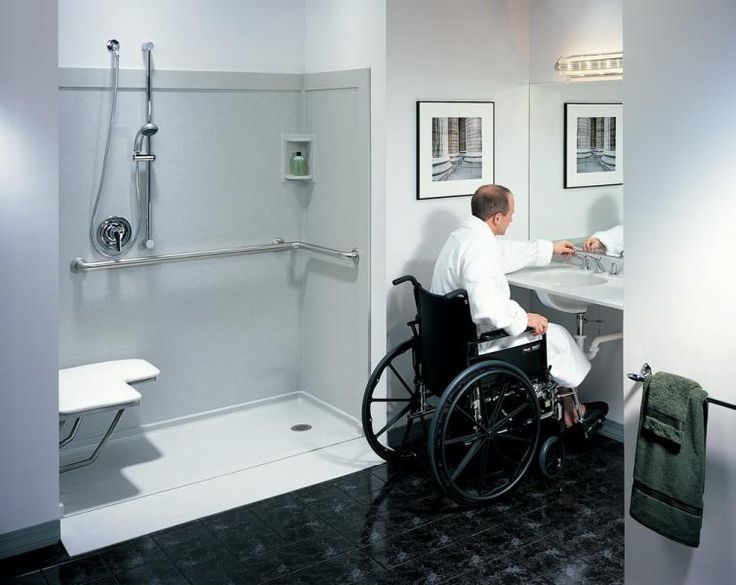 Curbless roll-in shower with a fold-down seat, grab bars and a roll-under sink for wheelchair access
